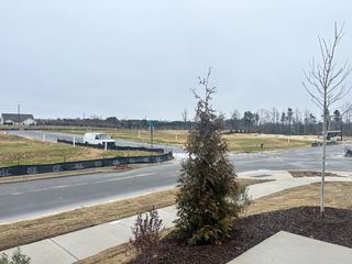 A developing neighborhood in The Manors at Haywood Glen by D.R. Horton, Knightdale, NC; open plots and trees line the street.