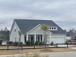 Street view A charming gray home with a spacious yard and porch in Waterside at Lakes of Cane Bay: Arbor Collection by Lennar (Summerville, SC).