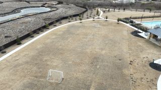 Community Amenities A spacious soccer field next to a pool and pavilion in Emory Crossing by David Weekley Homes (Hutto, TX).