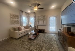 A cozy living room with elegant decor, featuring a plush sofa, stylish rug, wall art, and abundant natural light.