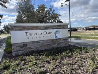 Street view Stylish entrance to Twisted Oaks Reserve at Highfield by Park Square Residential in Wildwood, FL, showcasing lush landscaping.
