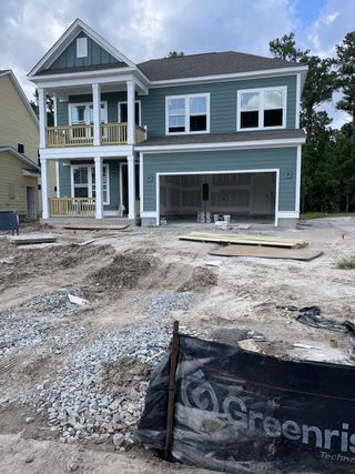 A charming blue two-story home under construction in Tidewater at Lakes of Cane Bay by Dream Finders Homes (Summerville, SC).