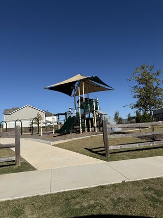 A beautiful playground with slides and shaded seating in Reserve at North Fork by Pulte Homes (Leander, TX).