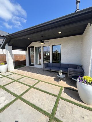 Street view A chic patio with sleek outdoor seating and modern pavers in Sweetgrass 50' by Perry Homes (Haslet, TX).