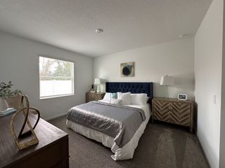 A chic master bedroom with a navy tufted headboard, rustic nightstands, and soft accent lighting.