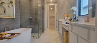 A luxurious master bathroom with a freestanding bathtub, glass-enclosed shower, and double vanity.