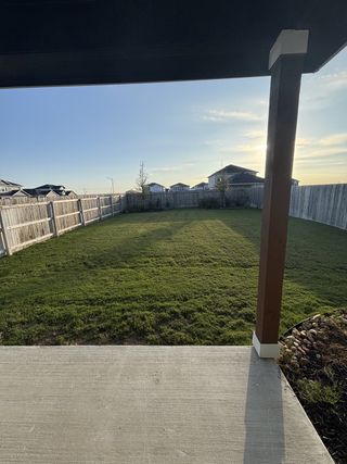 A spacious backyard with wooden fencing and a covered patio, perfect for outdoor living.