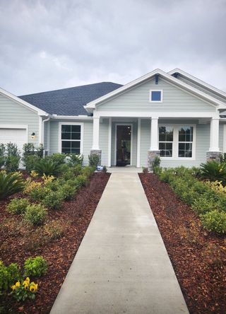 A charming light grey home with landscaped entry in Tributary 70' by David Weekley Homes (Yulee, FL).