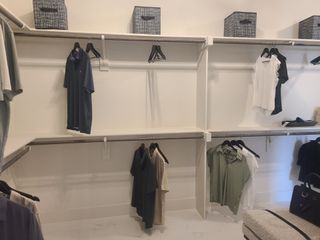 An organized walk-in closet with sleek shelving and modern storage baskets.