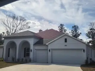 A charming white home with arched entry and a spacious garage in Fox Meadows by Maronda Homes (Middleburg, FL).