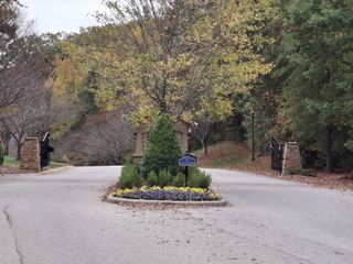 A gated entrance with autumn trees and landscaped roundabout in Handsmill on Lake Wylie by Kolter Homes (York, SC).