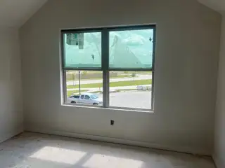 A bright room with large window and a view of the street outside. Simple, spacious, and filled with natural light.