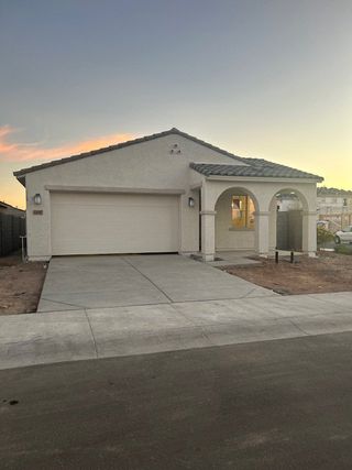 Street view A charming, modern home with elegant arches and a two-car garage in Allen Ranches: Fiesta Collection by Taylor Morrison (Litchfield Park, AZ).