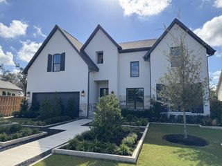 Street view A beautiful white brick home with dark shutters and a manicured lawn in Parmer Ranch - 60' by Westin Homes (Georgetown, TX).