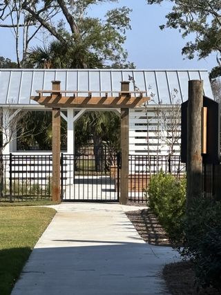 A charming entrance with a pergola and gated path in Liberty Hill Farm by K. Hovnanian® Homes, Mount Pleasant, SC.