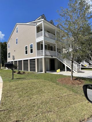 A modern beige home with spacious balconies and lush lawn in Wando Forest by J.Meyer Homes (Mount Pleasant, SC).