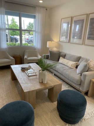 A cozy living room with a light wood coffee table, plush gray sofas, and modern art, creating a sophisticated, inviting atmosphere.