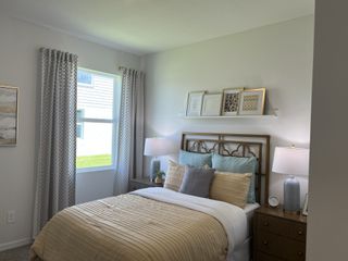 A cozy bedroom featuring elegant decor, soft lighting, and a stylishly made bed with accent pillows and framed art.