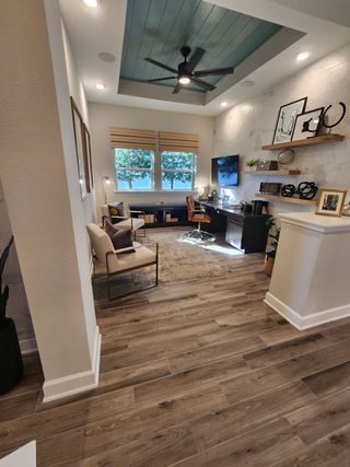 A sophisticated home office with built-in shelving, a coffered ceiling, and ample natural light for an inspiring workspace.