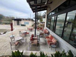 Model Home A modern outdoor seating area with red-cushioned chairs, ideal for relaxation.
