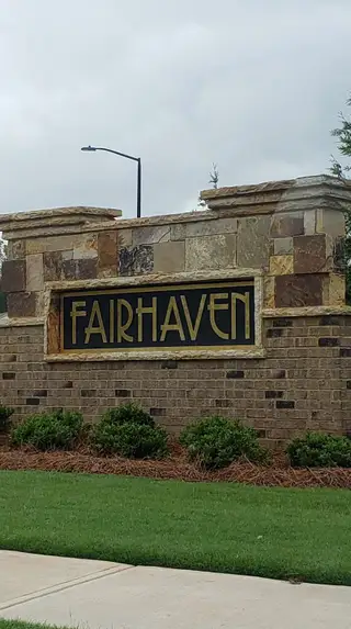 A welcoming stone entrance with landscaped greenery at Fairhaven by D.R. Horton (Lithia Springs, GA).