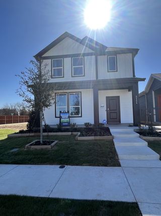 Street view A charming two-story home with a manicured lawn in Orchard Village by D.R. Horton (Fort Worth, TX).