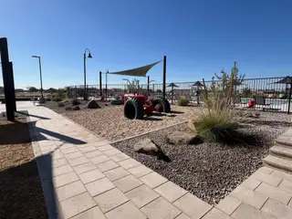 Community Amenities A scenic community playground with desert landscaping and a tractor in Silva Farms by Meritage Homes (Goodyear, AZ).