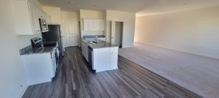 A modern kitchen with granite counters, sleek cabinets, and an open-plan layout leading to a spacious living area.