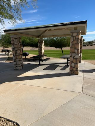 A charming park shelter with stone pillars and picnic tables in Seasons at Rio Rancho by Richmond American Homes (Surprise, AZ).