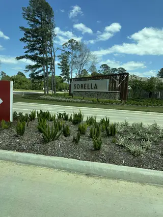 Street view A welcoming entrance to the Sorella community by M/I Homes, featuring lush greenery in Tomball, TX.