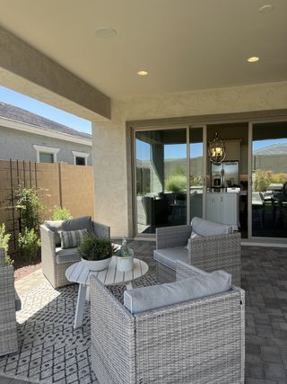 A cozy patio with wicker seating, a patterned rug, and a lovely view to the outside. Perfect for relaxing and entertaining.