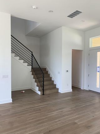 An airy living space with elegant wood flooring, modern stairs, and minimalist design elements.