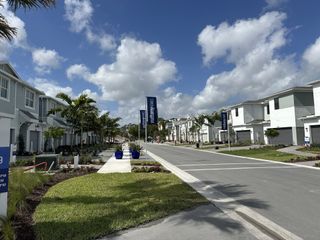 Modern homes line a palm tree boulevard in the Forest community by Mattamy Homes, Lake Worth, FL.
