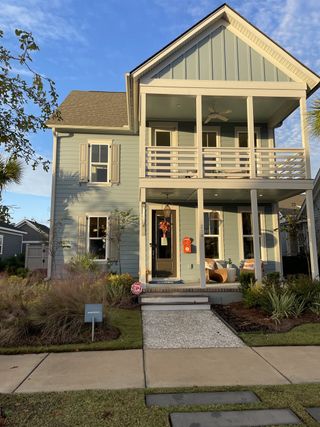 Charming two-story home with a welcoming porch and lush landscaping in Nexton by Pulte Homes (Summerville, SC).