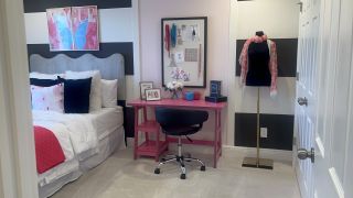 Model Home A chic bedroom featuring a stylish pink desk, plush bed, and fashion mannequin with a bold black-and-white accent wall.