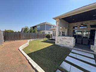 Street view A charming stone patio and landscaped yard in Blackhawk by Scott Felder Homes (Pflugerville, TX) provide a perfect outdoor retreat.