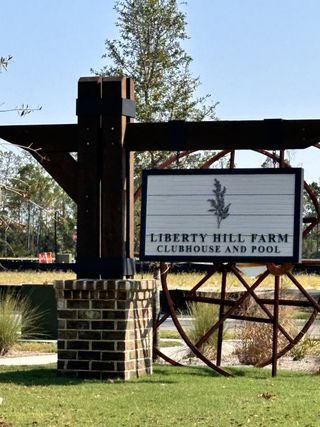 Charming entrance to Liberty Hill Farm by K. Hovnanian® Homes in Mount Pleasant, SC, featuring rustic accents.