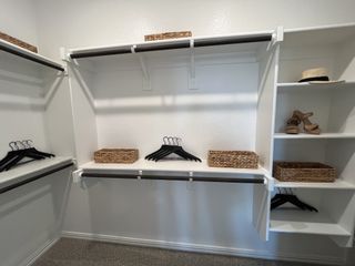 A spacious walk-in closet with sleek shelving and stylish storage in Solterra by Chesmar Homes (Mesquite, TX).