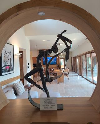 A modern interior with an elegant sculpture, open layout, and stylish wooden accents.