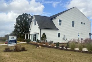 Street view A charming white home with a manicured lawn in Harmony by Eastwood Homes (Harrisburg, NC).