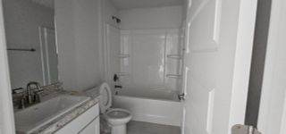A modern bathroom with sleek fixtures, granite countertop, and a white bathtub. Perfect blend of style and functionality.
