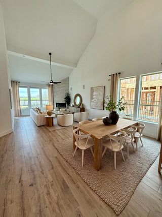 Model Home An airy open-concept living and dining area with wood floors, neutral decor, and ample natural light.