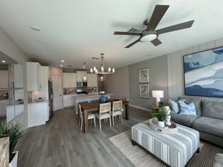 Model Home A modern open-plan living area with sleek kitchen, cozy seating, and stylish decor in neutral tones.