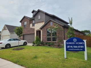 A charming brick home with a stone accent and manicured lawn in Courts Of Bonnie Brae by Sumeer Homes, Denton, TX.