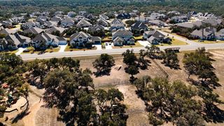Aerial view of charming homes amidst lush greenery in Caliterra by Scott Felder Homes, Dripping Springs, TX.