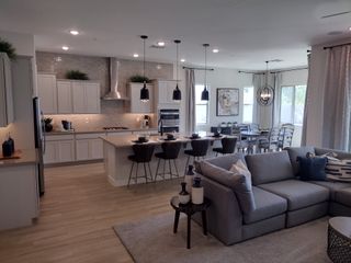 An open-concept living area with a modern kitchen, sleek island seating, and elegant dining space.