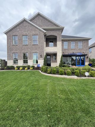 A majestic brick home with manicured shrubs in Sutton Fields by Mattamy Homes (Celina, TX).