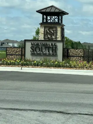 Welcome to Northpark South by Century Communities in Porter, TX—an inviting entrance with landscaping and a stylish sign.