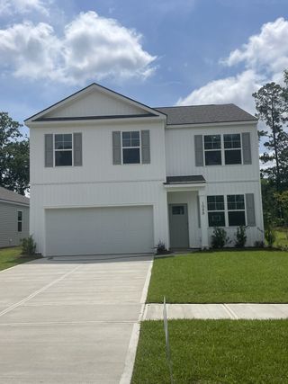 A modern white two-story home with a spacious garage in Pineview North by D.R. Horton (Summerville, SC).