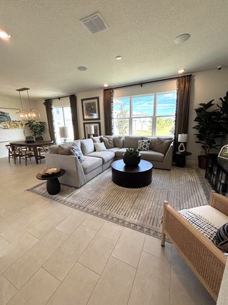 A cozy living room featuring a large sectional, elegant rug, and ample natural light.
